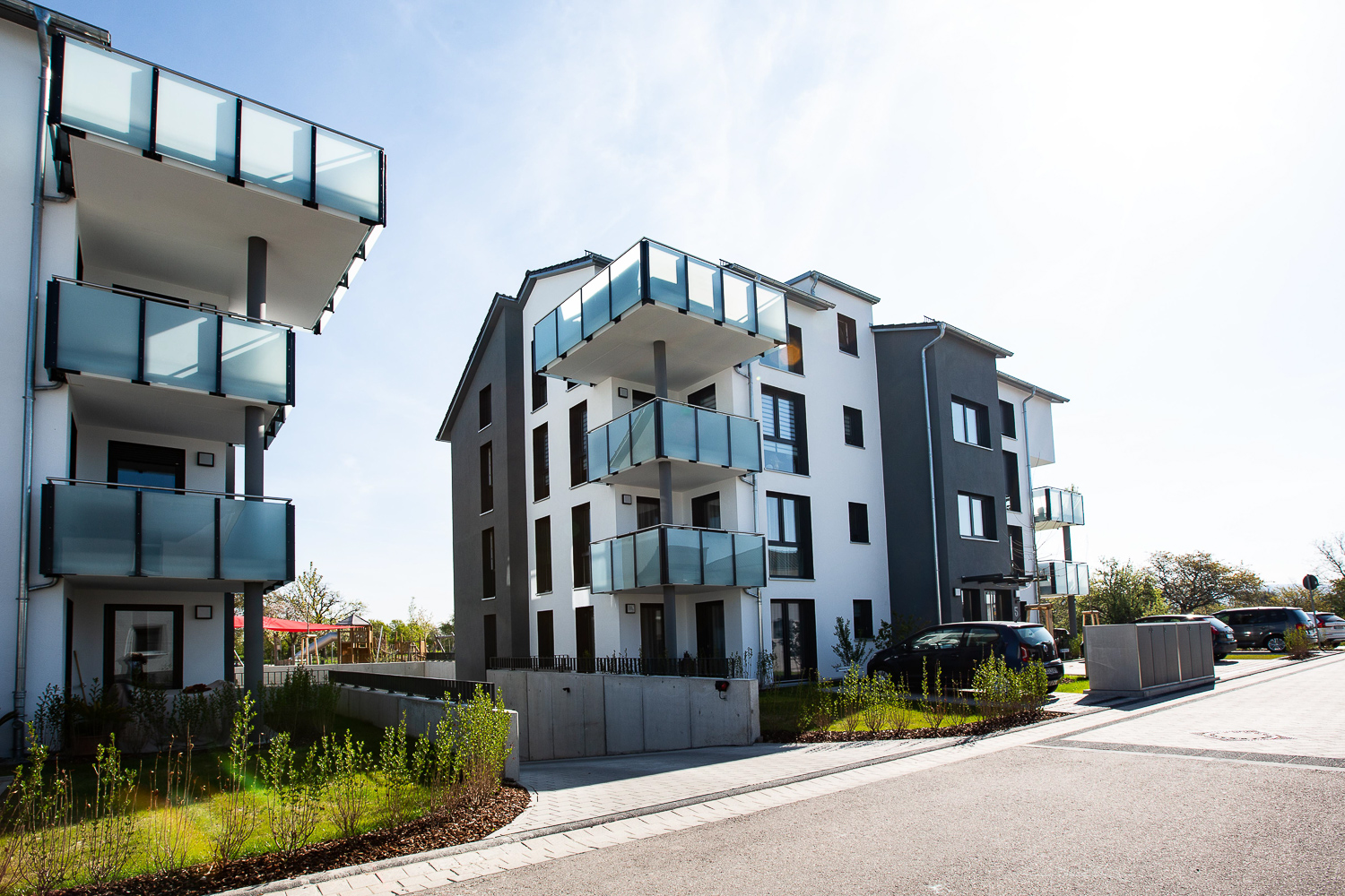 Moderne Mehrfamilienhäuser mit Balkonen und gepflegtem Grünbereich.